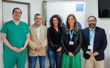 Grupo de profesionales posando frente a un banner de la Clínica Bupa Reñaca.