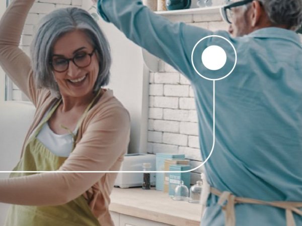 Una pareja bailando en una cocina, rodeados de un ambiente acogedor.